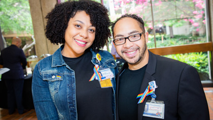 Man and woman wearing rainbow pride ribbons on their lapels