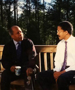 Dr. Louis W. Sullivan and Dr. Paul Sullivan conversing outdoors