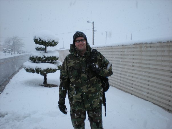 Man outdoors in the snow wearing military camo