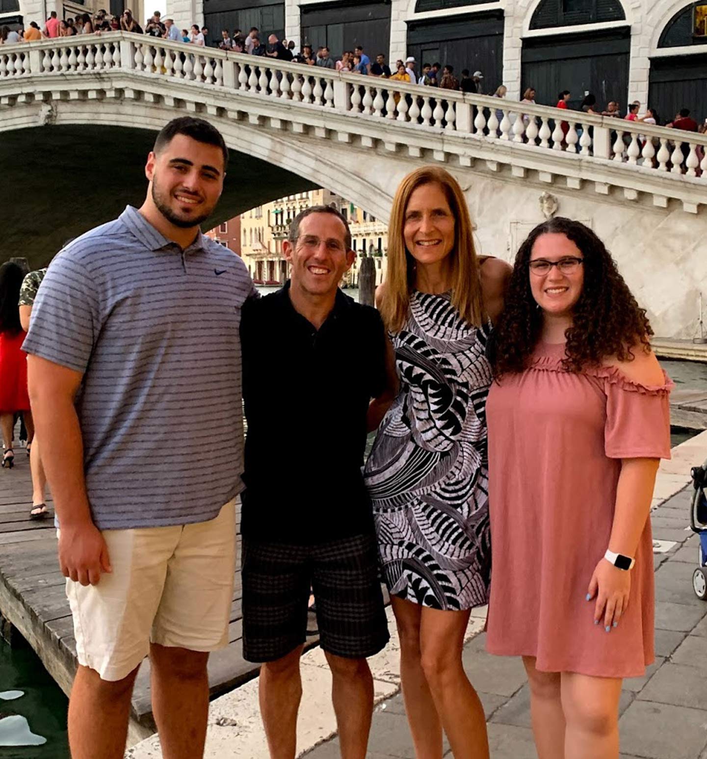 Four people standing by a canal