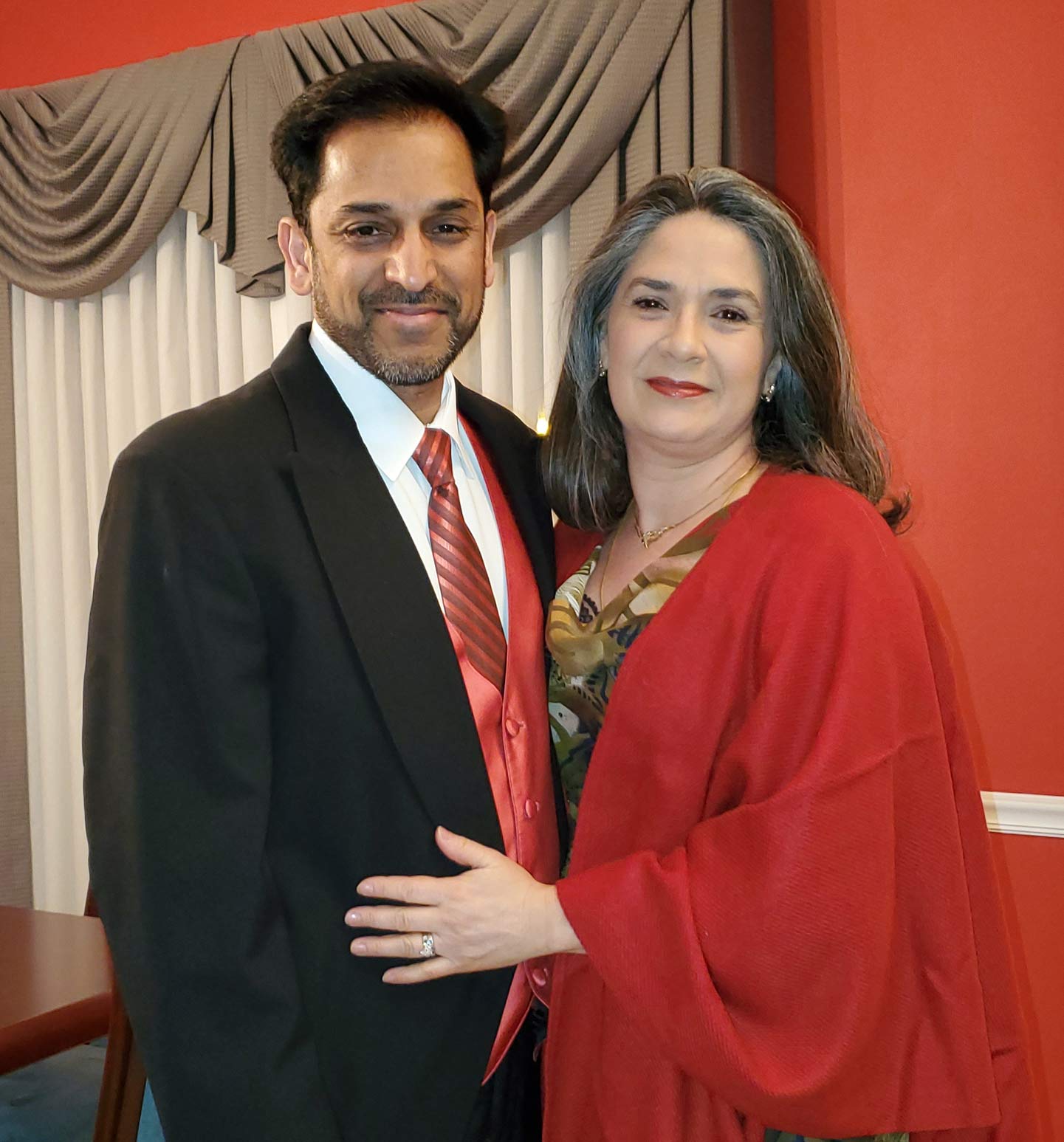 Man in suit and woman in red dress standing in red room