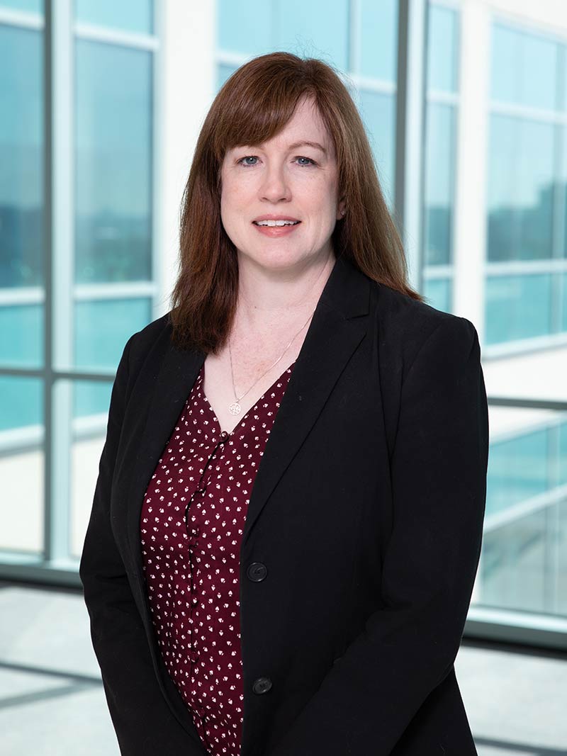 Woman with red hair wearing black blazer