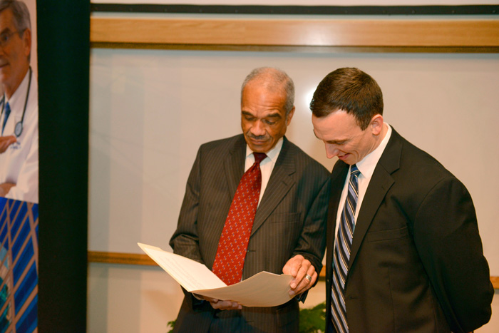 Two men in suits looking at a folder