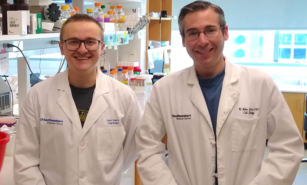 Two men in white coats in a lab