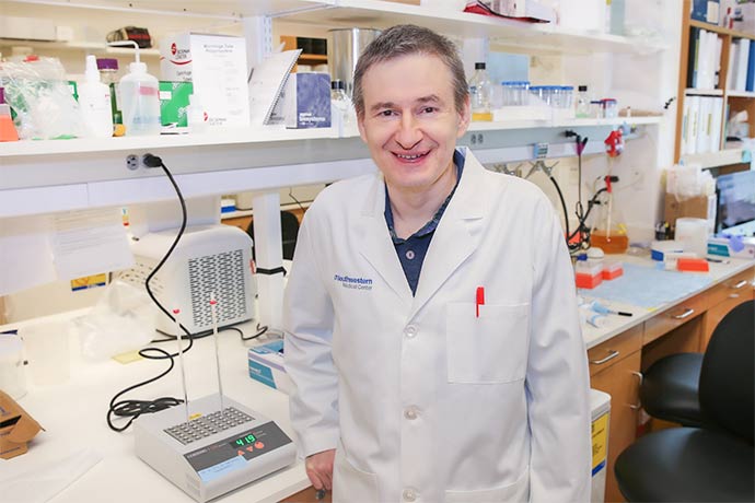 Grishin standing in lab wearing white lab coat