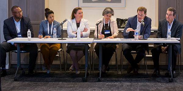 three men and three women contest judgest sit at long table taking notes