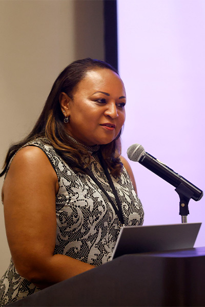 woman in black dress at podium