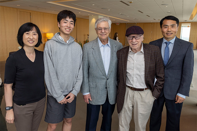 Four men and one woman smile for the camera.