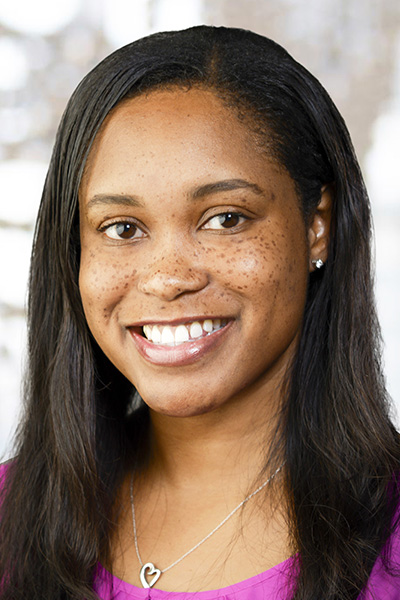 Janelle Traylor headshot - young black woman with shoulder-length dark hair, freckles and a purple shirt