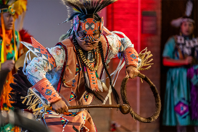 native american dancer in costume performs on stage