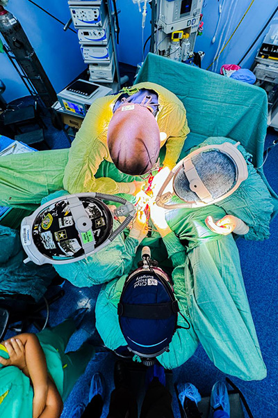 Overhead view of 4 people performing surgery.