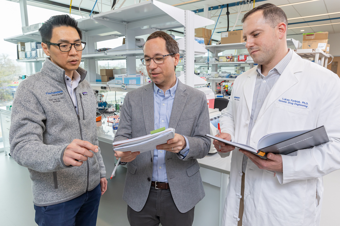 Three men collaborating in a laboratory.