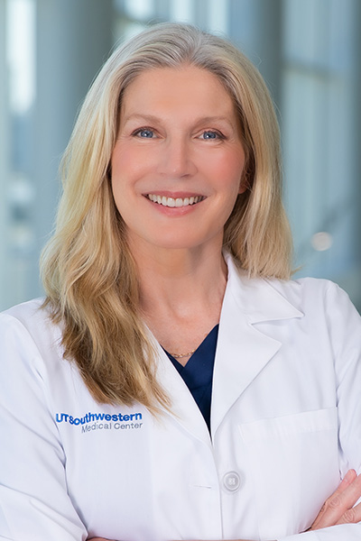 Smiling woman with blond hair wearing a UT Southwestern lab coat.