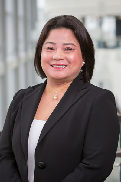 smiling Asian woman with short dark hair wearing white shirt and black blazer