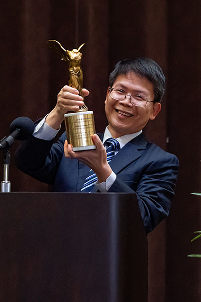 Dr. Zhijian Chen accepts crystal trophy Lasker award at podium