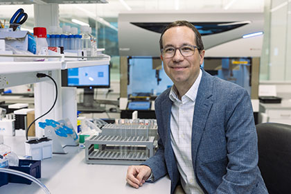 Dr. Siegwart sits in lab near computers and test tubes