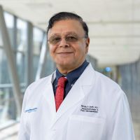 Grish Joshi, MD., southeast Asian man, wearing glasses, wearing medical coat