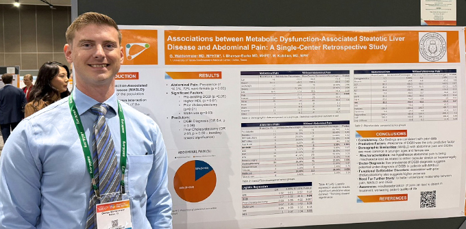 a resident at a national conference in front of a scientific poster