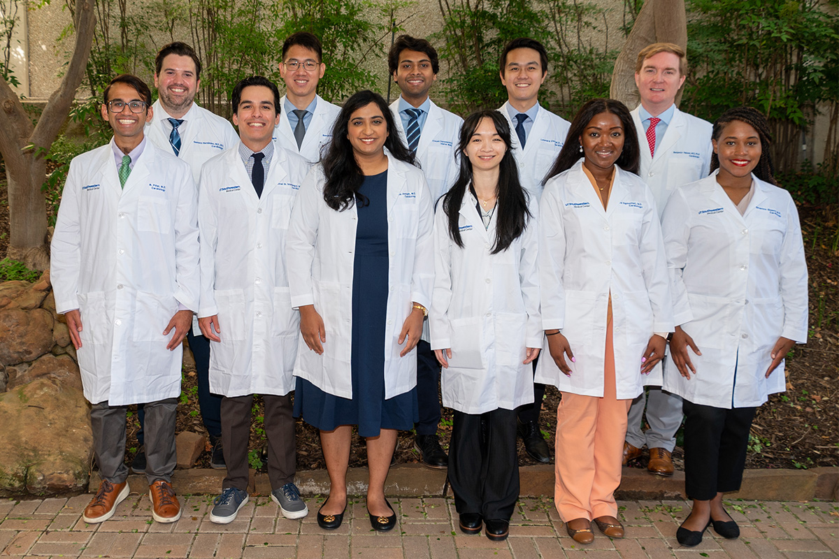 2024-25 First Year Cardiology Fellows standing in a group in front of tress and schrubs 