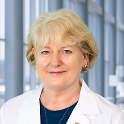 Dr. Vivyenne Roche wearing a white lab coat standing in the CUH lobby