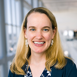 Dr. Ariella Hanker wearing a floral shirt and a blue sweater standing in the Clements University Hospital lobby