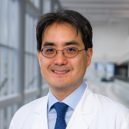 Dr. Makato Ishii wearing glasses and a white lab coat