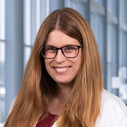 a woman with long brown hair wearing glasses