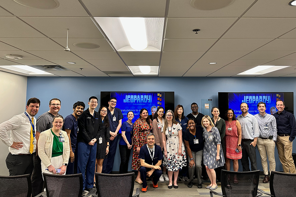 trainees and faculty lined up in a conference room