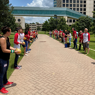 Teams line opposite sides of a walkway at UT Southwestern to have a water balloon toss