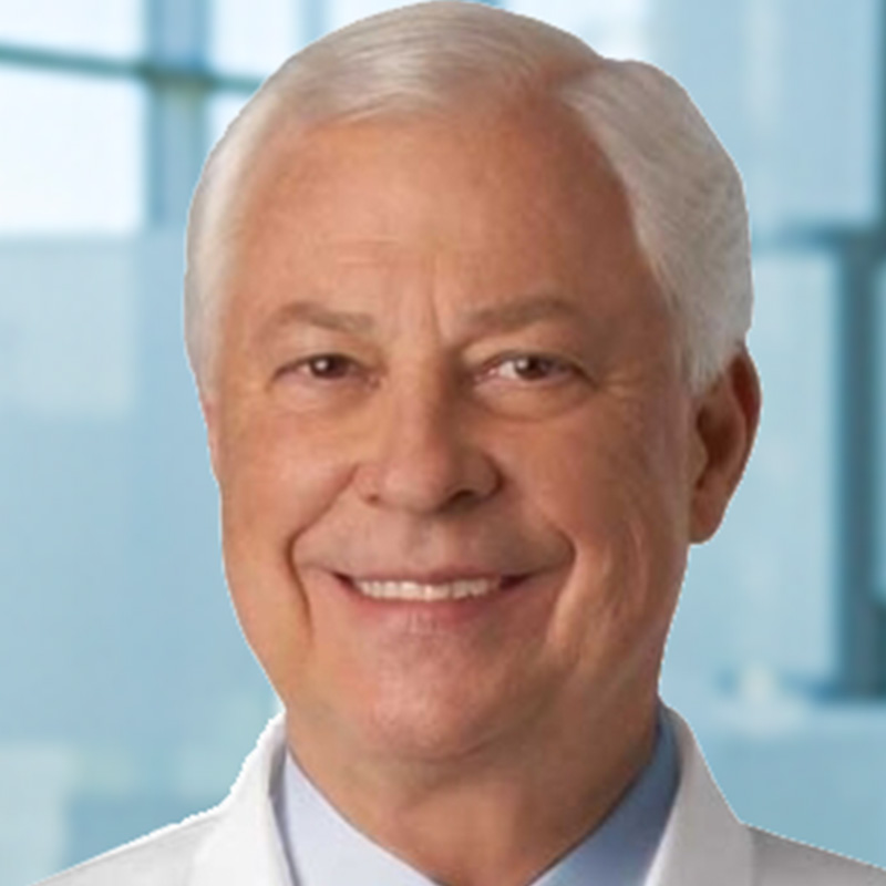 Smiling man with gray hair wearing a light blue dress shirt and white lab coat