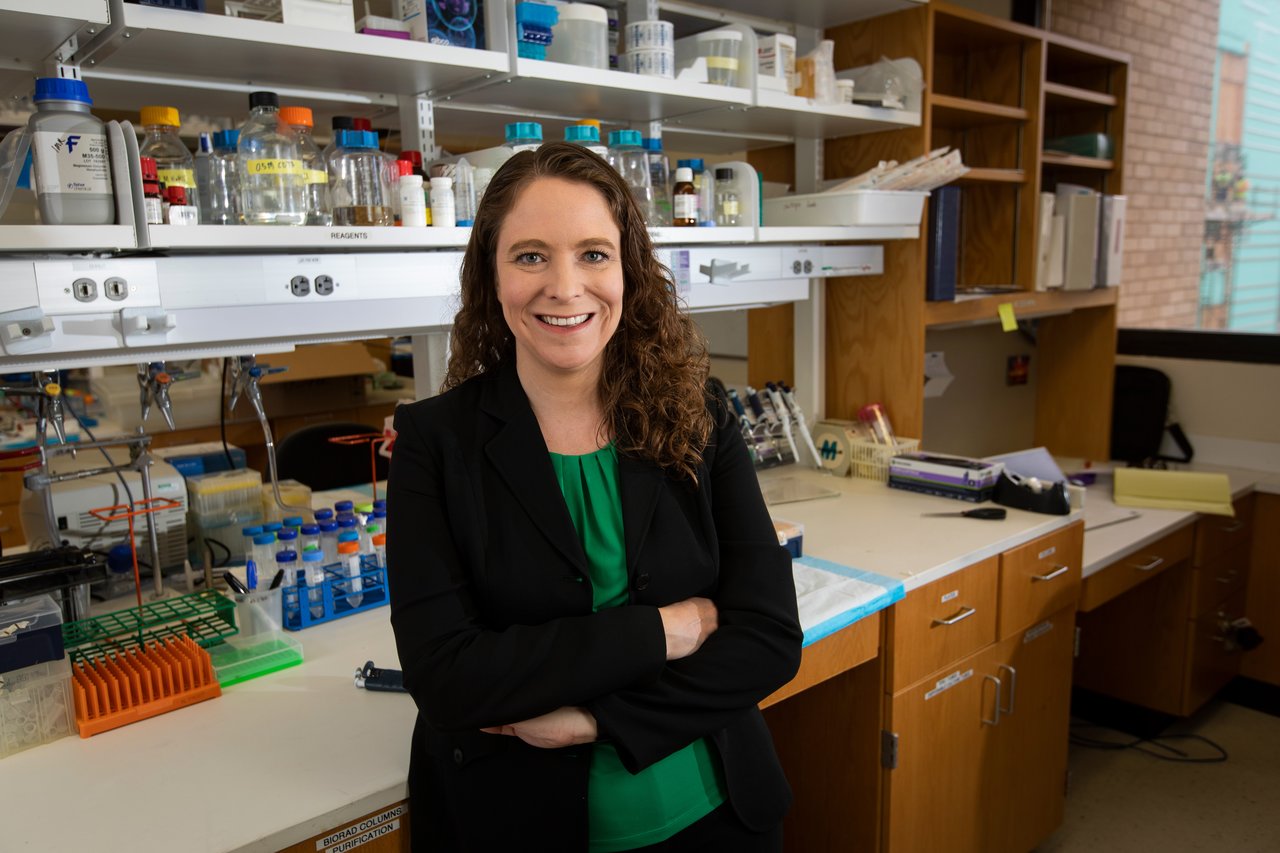 Dr. Wetzel posed in her lab wearing a green shirt