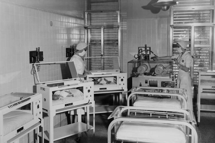 Two nurses tend to babies in incubators in 1973.