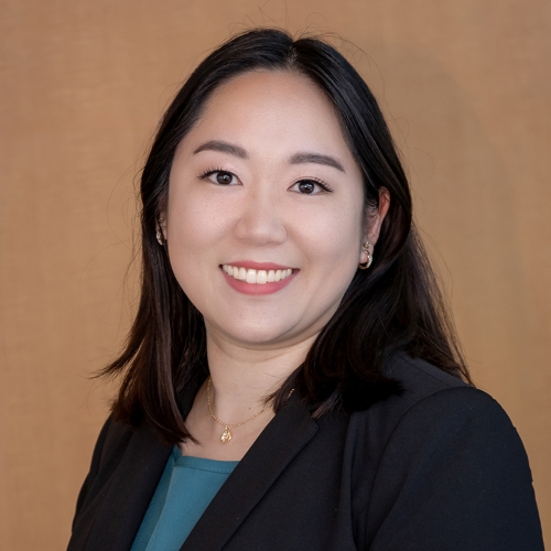 Dr. Harada smiling headshot of women with long black hair, black blazer and blue shirt