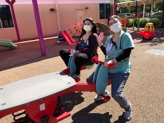 Two women sitting on playground equipment