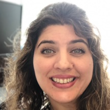 closeup of smiling white female with wavy dark hair and light eyes