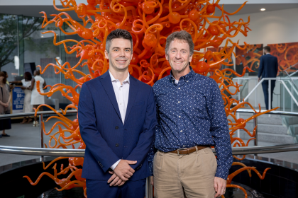 two men in front of sculpture