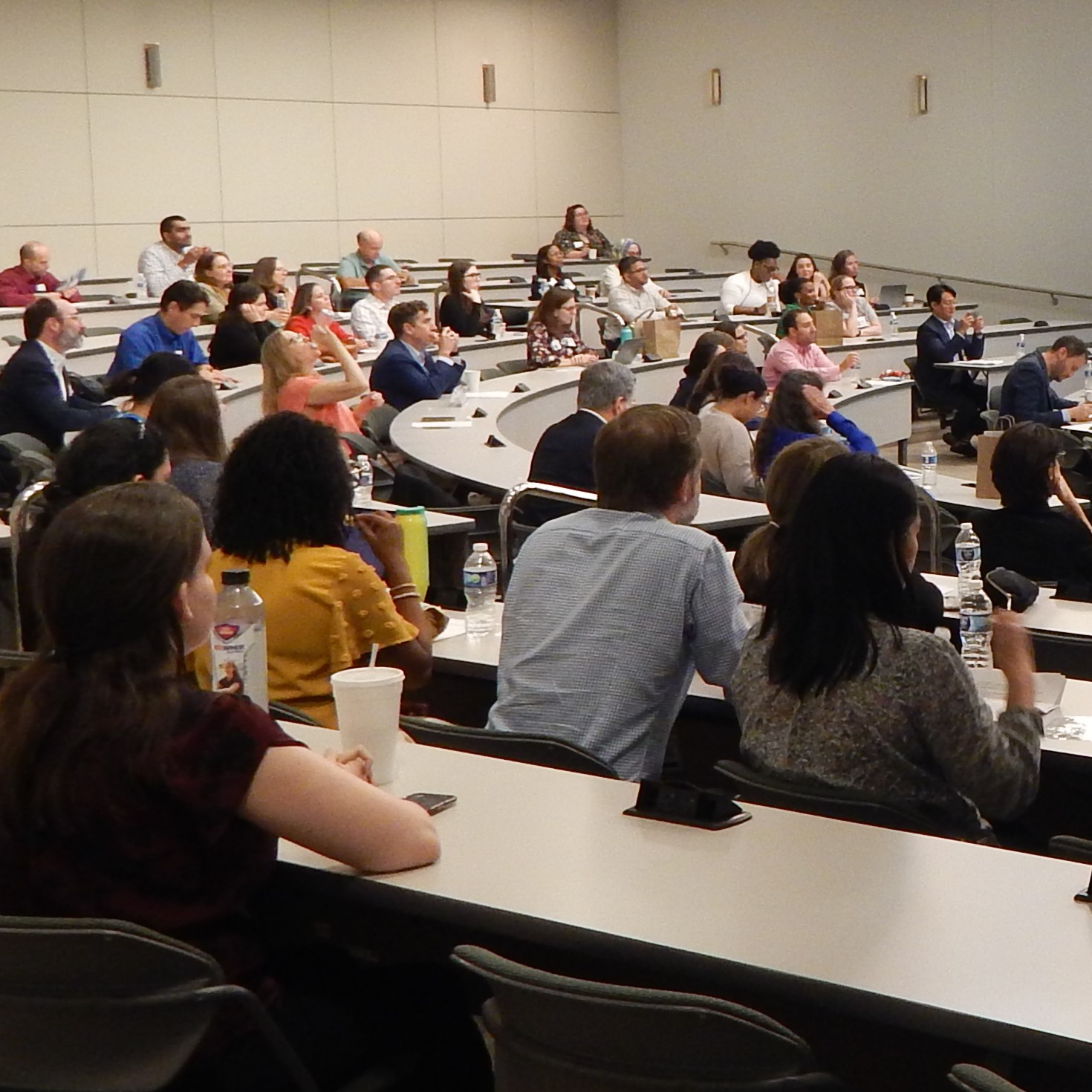 students at lecture hall tables in class setting