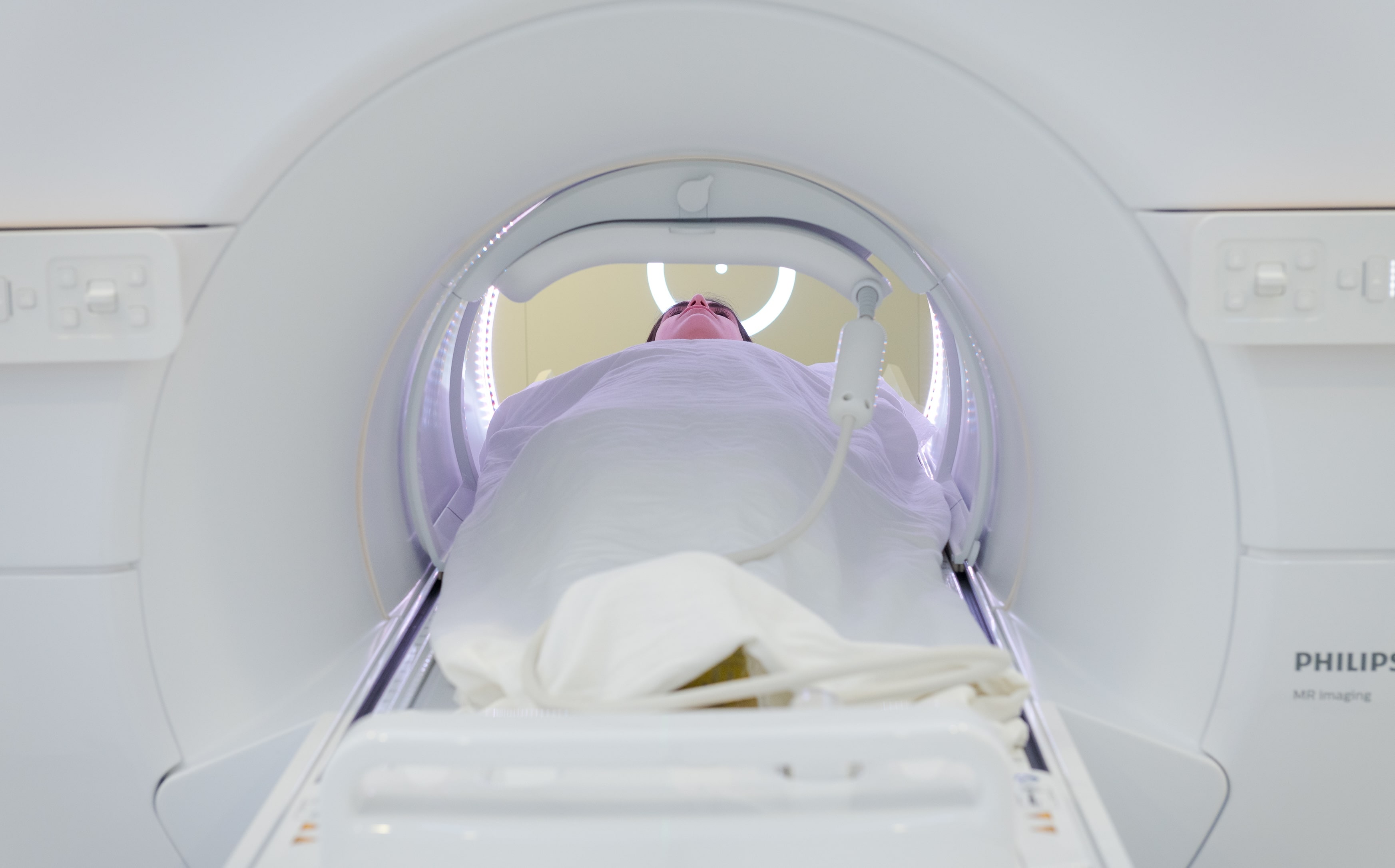 Woman completely in a white radiation machine.