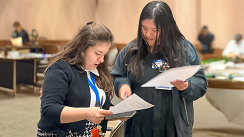 Two women reviewing papers