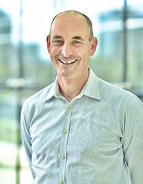 Mark Diamond, M.D., Smiling man with receding gray hair, wearing a plaid shirt.