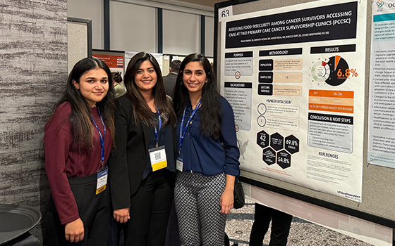 3 women in front of research poster