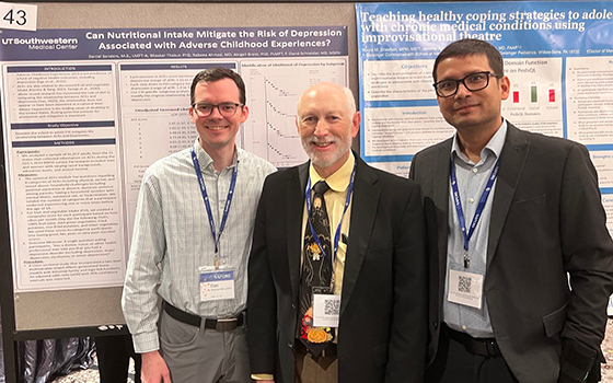 3 men standing in front of a research poster