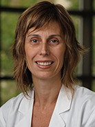 Woman with neck-length wavy blond hair wearing a white coat with UT Southwestern Medical Center logo