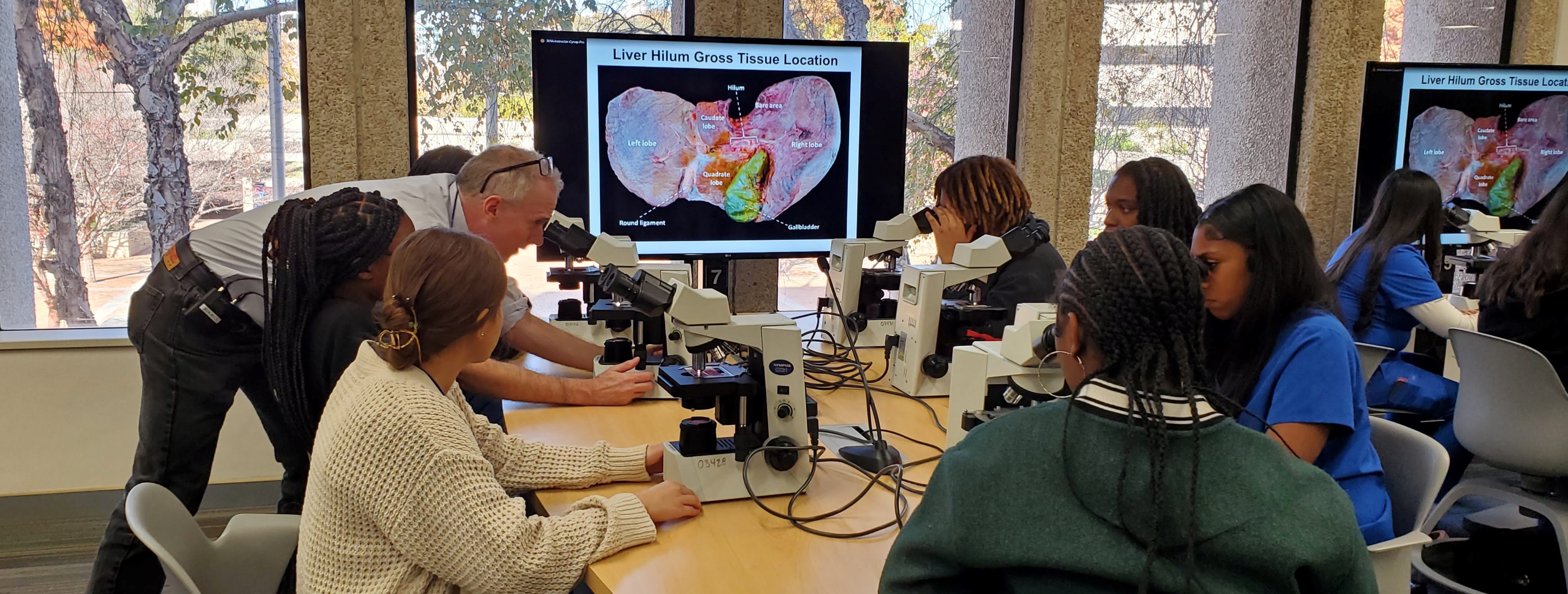 High school students learn about how to identify tissue and arteries by microscope from Dr. Peter Michaely