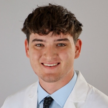 headshot of young man with black curly hair