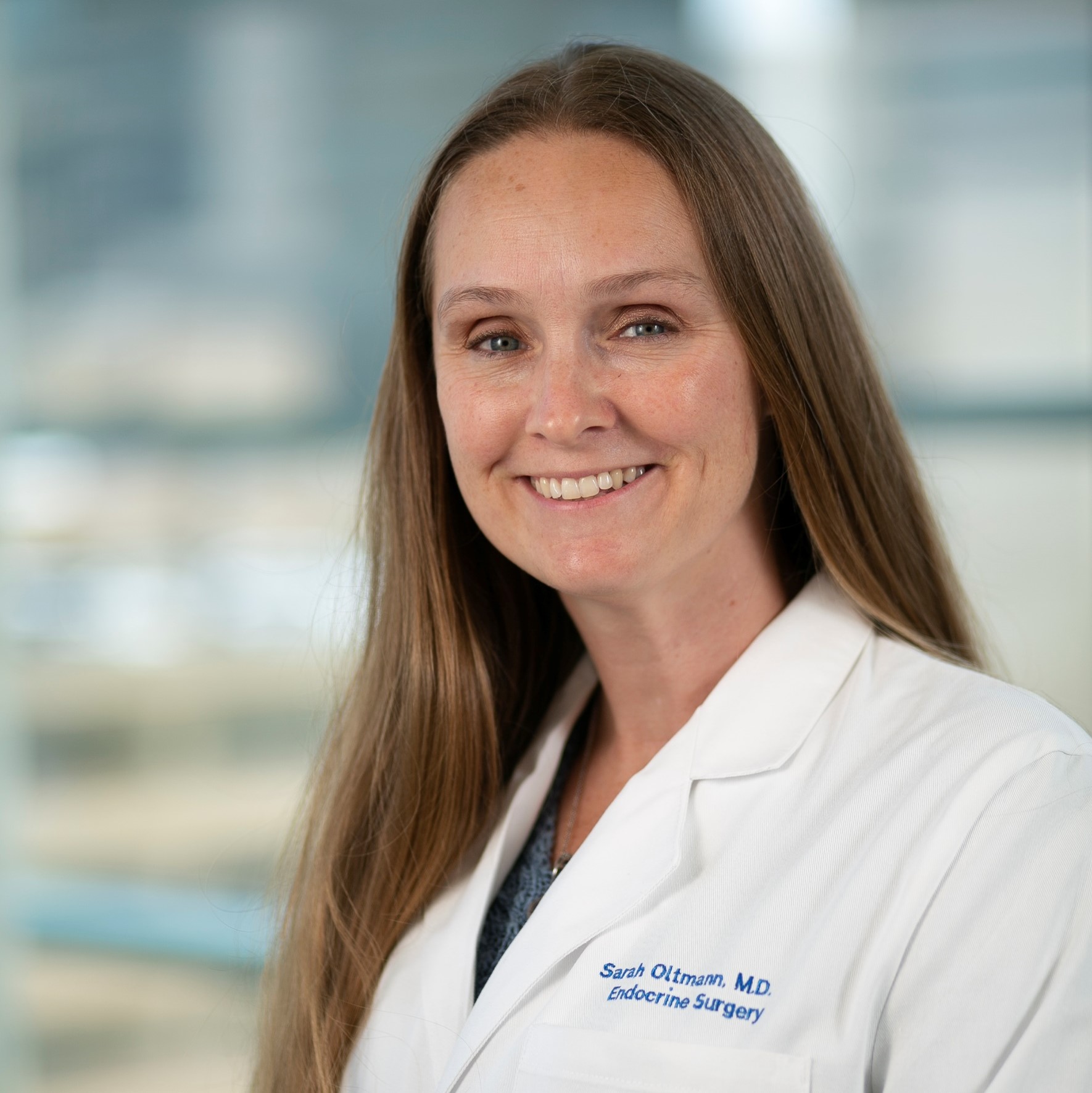 smiling woman in a white lab coat