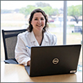 faculty member sitting at desk with laptop