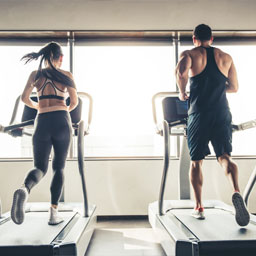 A man and woman running on the treadmill