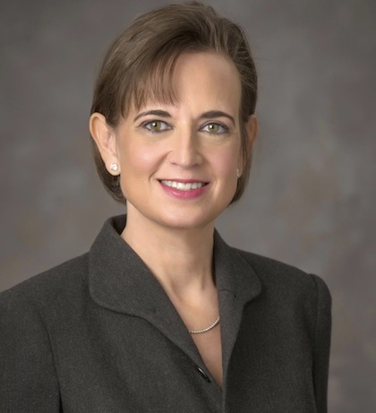 A woman with brown hair and black blazer
