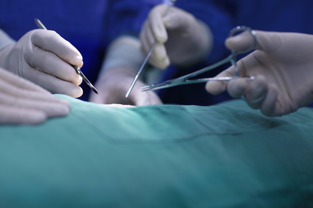 Hands of the operating room staff performing an operation